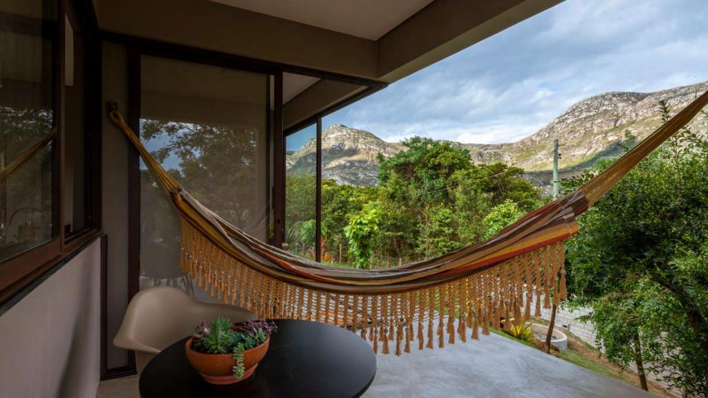 hamaca en una habitación con vistas a las montañas en Chalé Aurora da Serra - Lapinha da Serra en Santana do Riacho