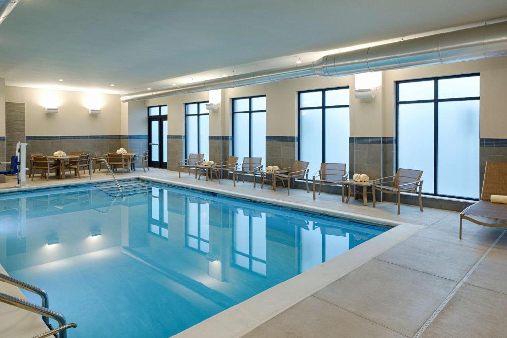 una piscina con tavoli e sedie in un edificio di Hyatt House Columbus OSU Short North a Columbus