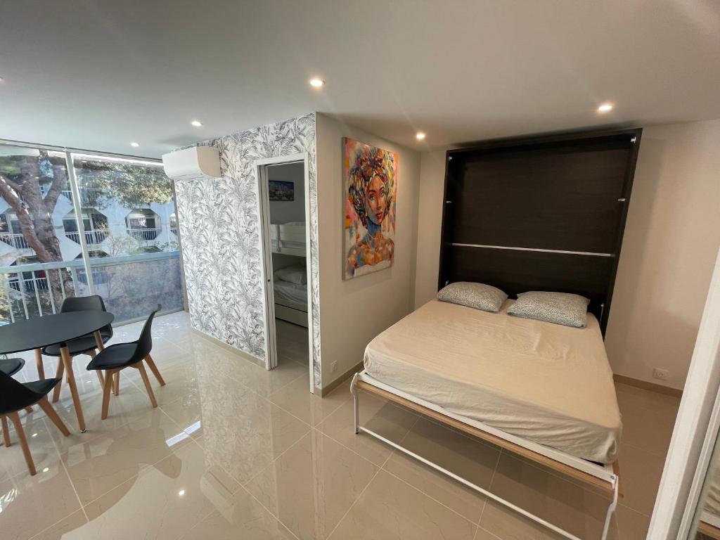 a small bedroom with a bed and a dining room at Grand studio en centre ville et à 50 mètres du port, climatisé in La Grande Motte