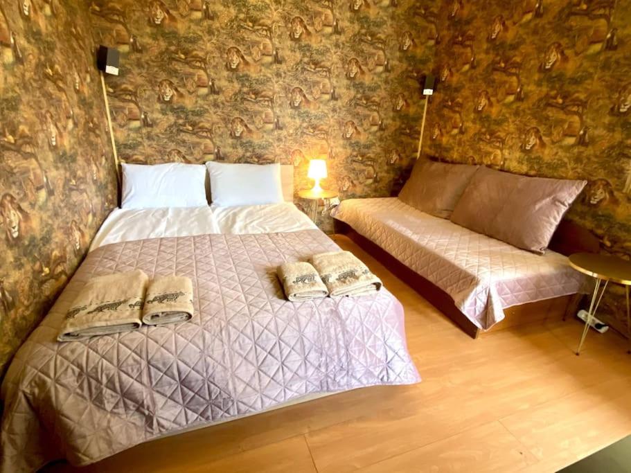 1 dormitorio con 2 camas en una pared de piedra en Guest ROOMS with living room, dining room and kitchen next to CENTER SOFIA en Sofía