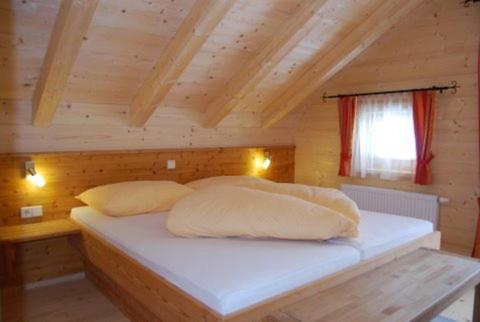A bed or beds in a room at Achenseer Hüttendörfl