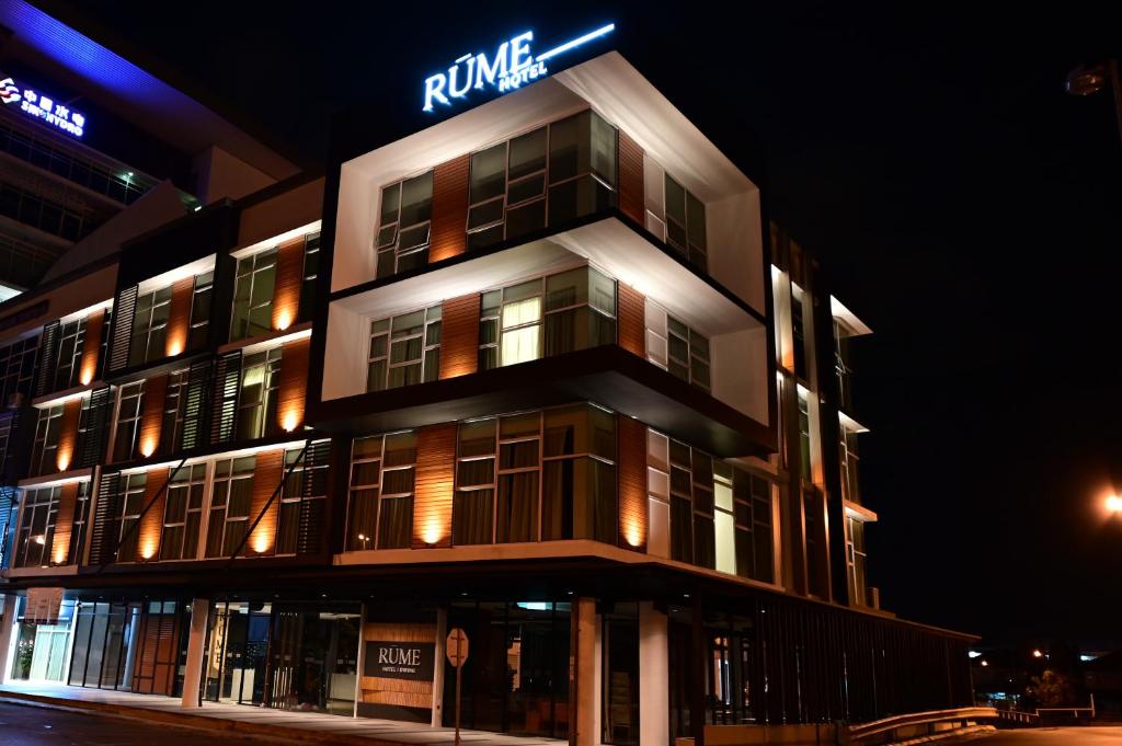 un edificio alto con un cartel encima en Rume Hotel en Kuching