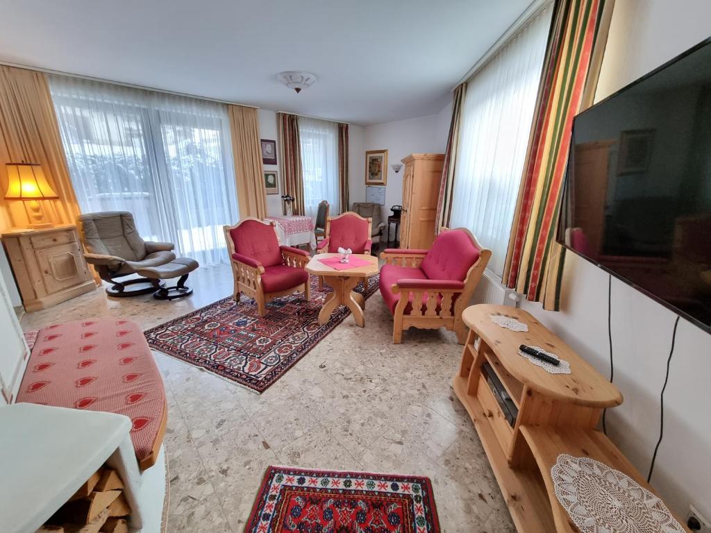 ein Wohnzimmer mit rosa Stühlen und einem TV in der Unterkunft Apartments Juri & Hermann 1 in Bad Kleinkirchheim