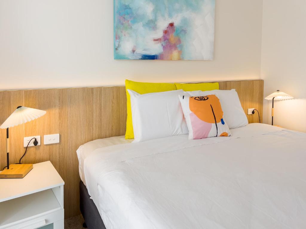 a bedroom with a bed and a desk with two lamps at A1 Motels and Apartments Port Fairy in Port Fairy
