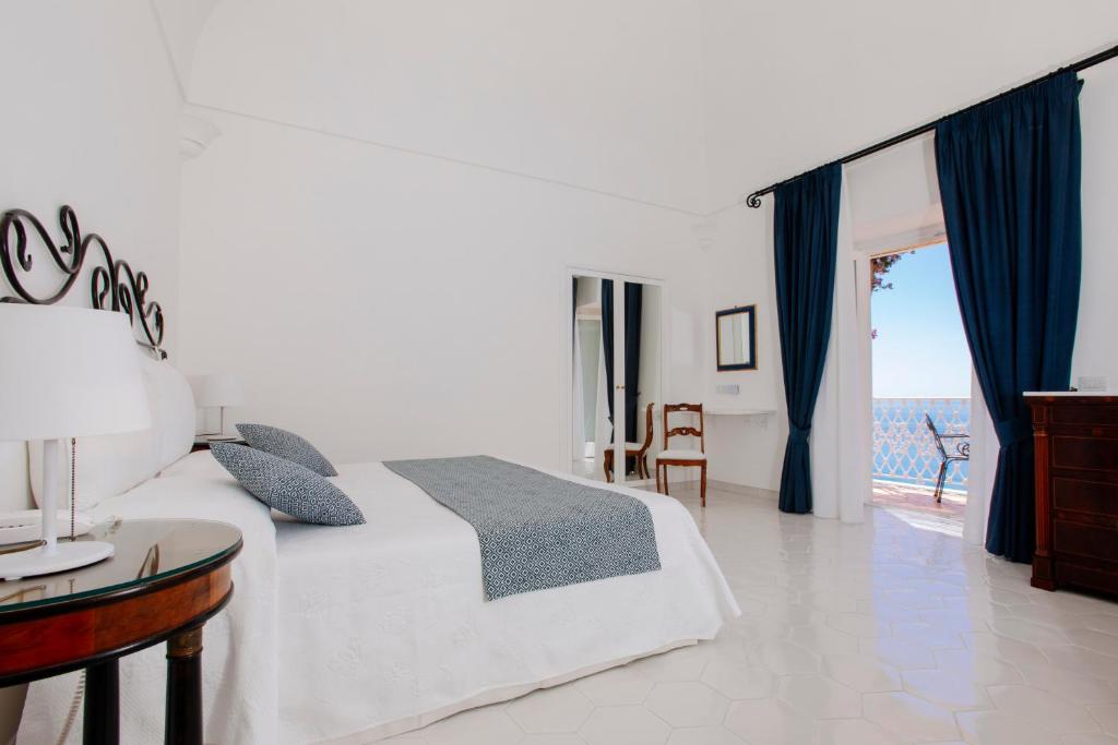 a bedroom with a bed and a view of the ocean at La Bizantina Luxury Villa in Positano