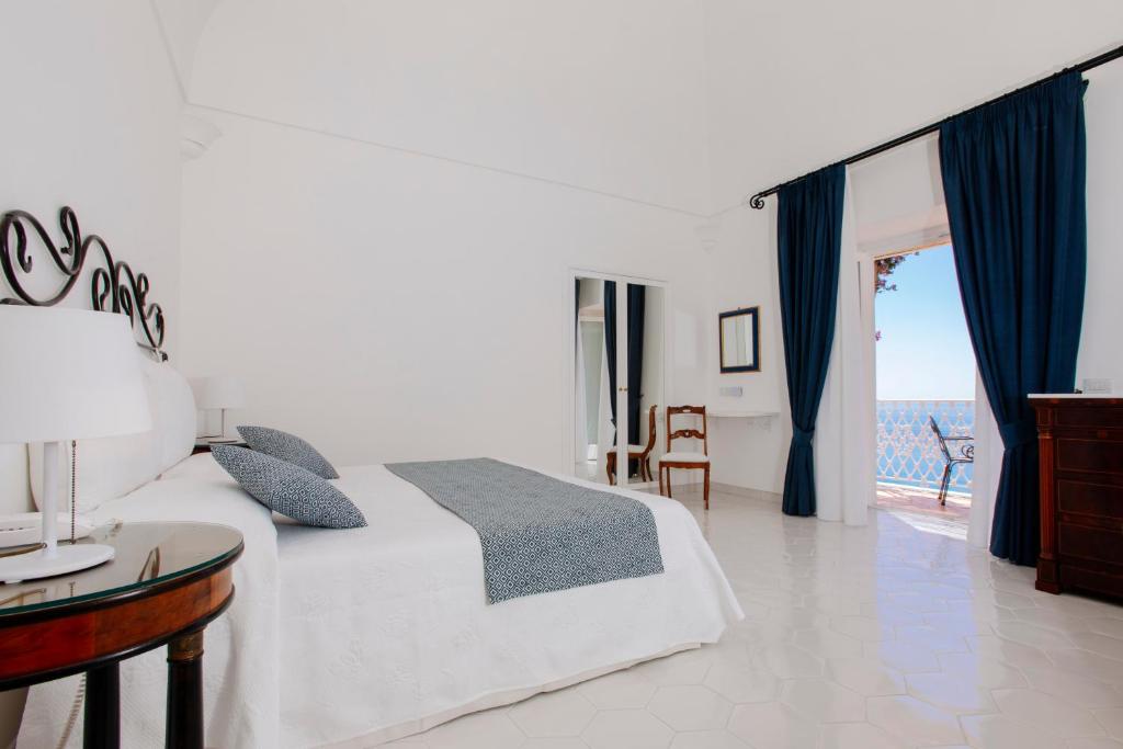 1 dormitorio con cama y vistas al océano en La Bizantina Luxury Villa, en Positano