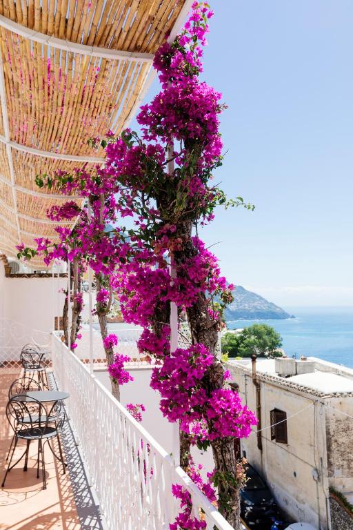 a tree covered in purple flowers on a balcony at La Bizantina Luxury Villa in Positano