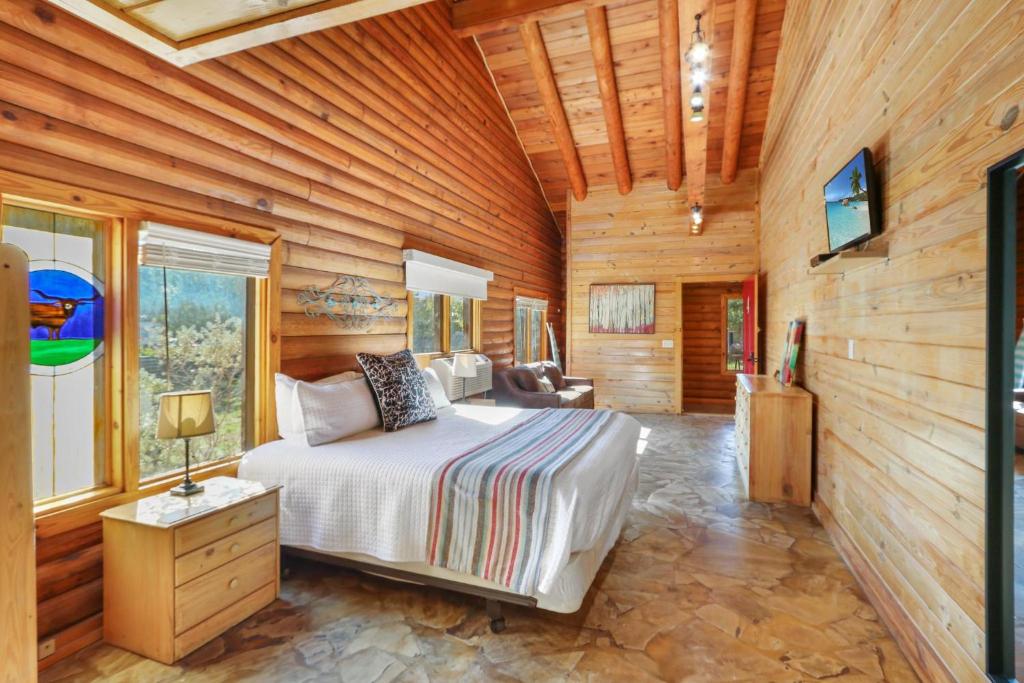 ウィンバリーにあるWimberley Log Cabins Resort and Suites- Unit 4の木製の壁のベッドルーム1室(ベッド1台付)