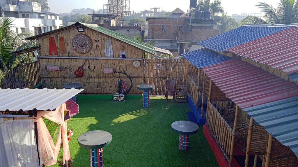 an outdoor area with stools on the grass in a building at Tridhara HomeStay in Guwahati