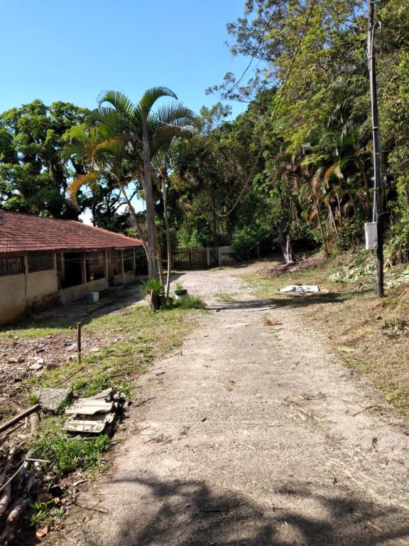 polna droga obok domu i drzew w obiekcie Pedacinho do Paraiso w mieście Mongaguá