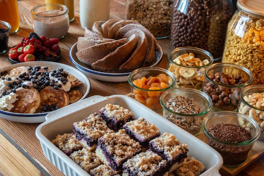 a table topped with different types of pastries and desserts at Wellness Hotel Šedý Vlk in Harrachov
