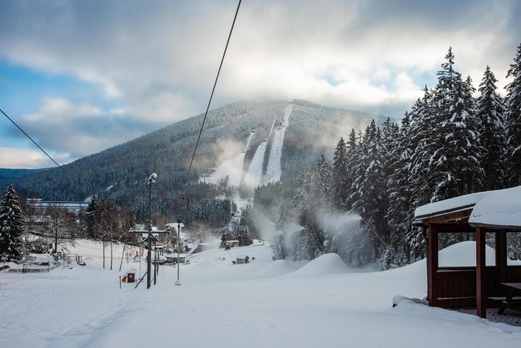 a ski slope with a ski lift in the snow at Wellness Hotel Šedý Vlk in Harrachov