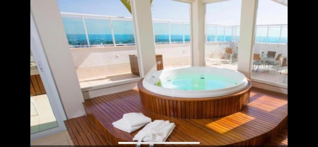 bañera grande en una habitación con ventana grande en Flat hotel saint moritz, en Brasilia