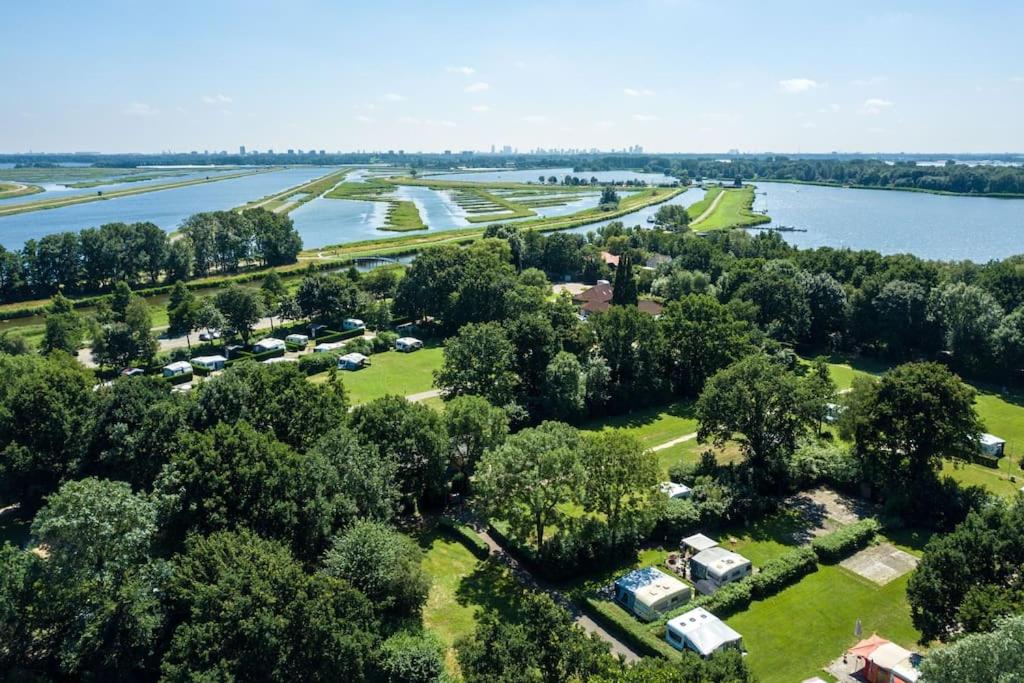 Zevenhuizen的住宿－The Little House by the Rottemeren，享有毗邻河流的公园的空中景致