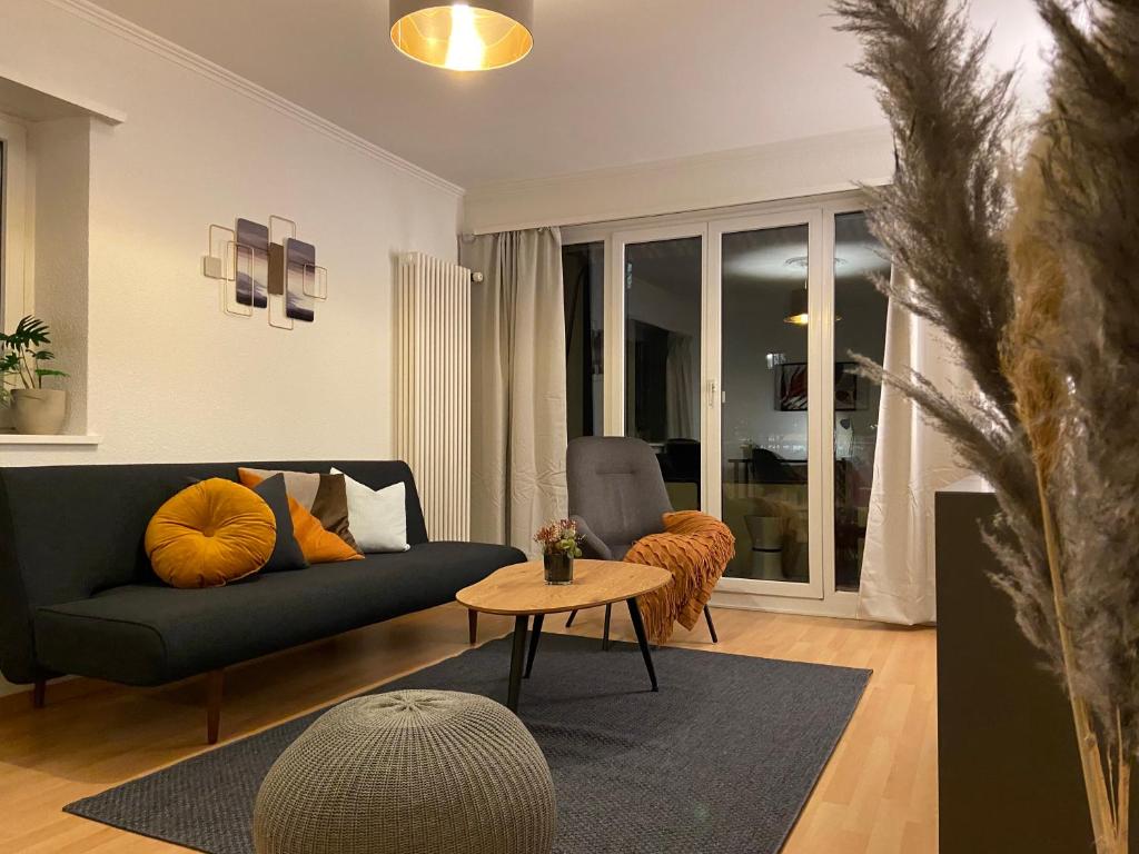 Comfort 1 and 2BDR Apartment close to Zurich Airport في زيورخ: غرفة معيشة مع أريكة وطاولة