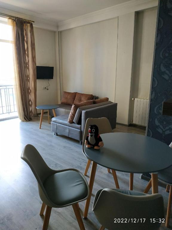 a living room with a couch and a table and chairs at Apartment Sandra in Tbilisi City