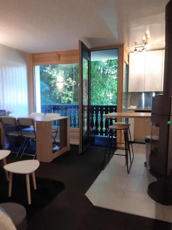 une chambre avec des tables et des chaises ainsi qu'une cuisine dans l'établissement Appartement en station de ski à 700 m des télécabines et 100 m du centre-village, aux Carroz d'Arâches