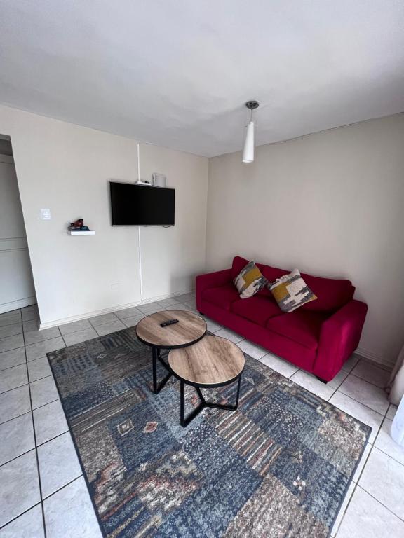 een woonkamer met een rode bank en een tafel bij 3D 2B cerca playa y centro, Park Surf in Iquique