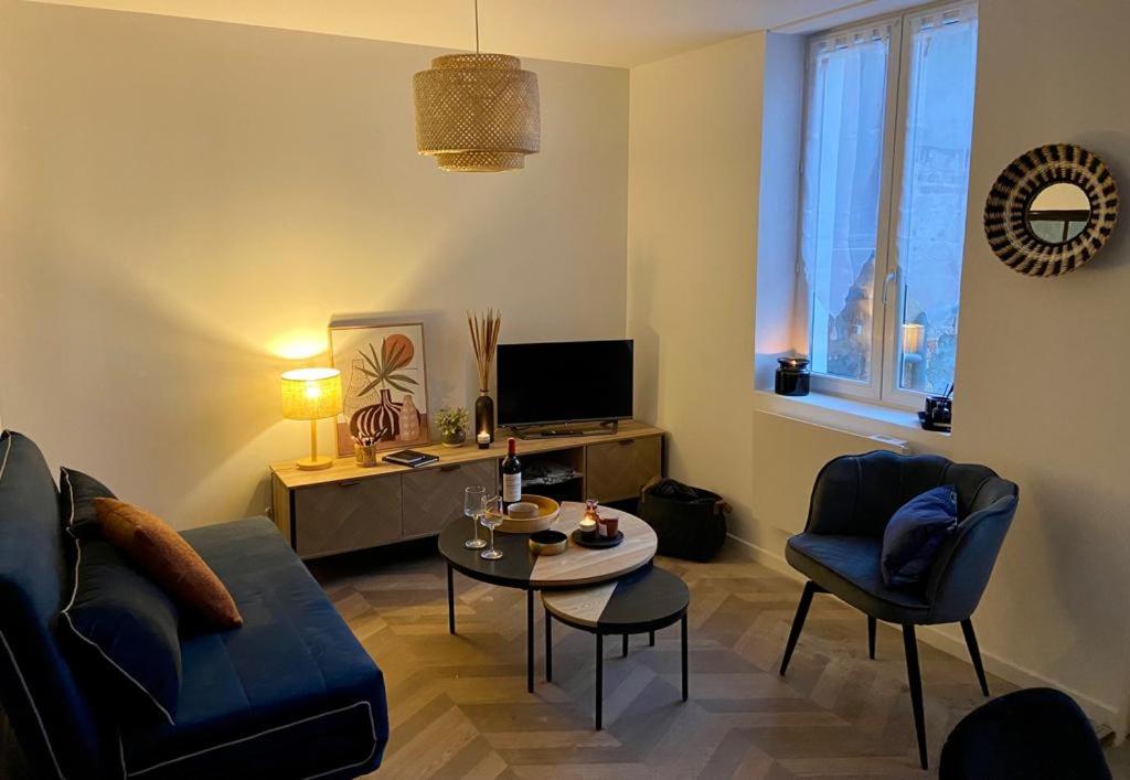 a living room with a couch and a table at Maison Hyper centre-Hôpital et parking in Moulins