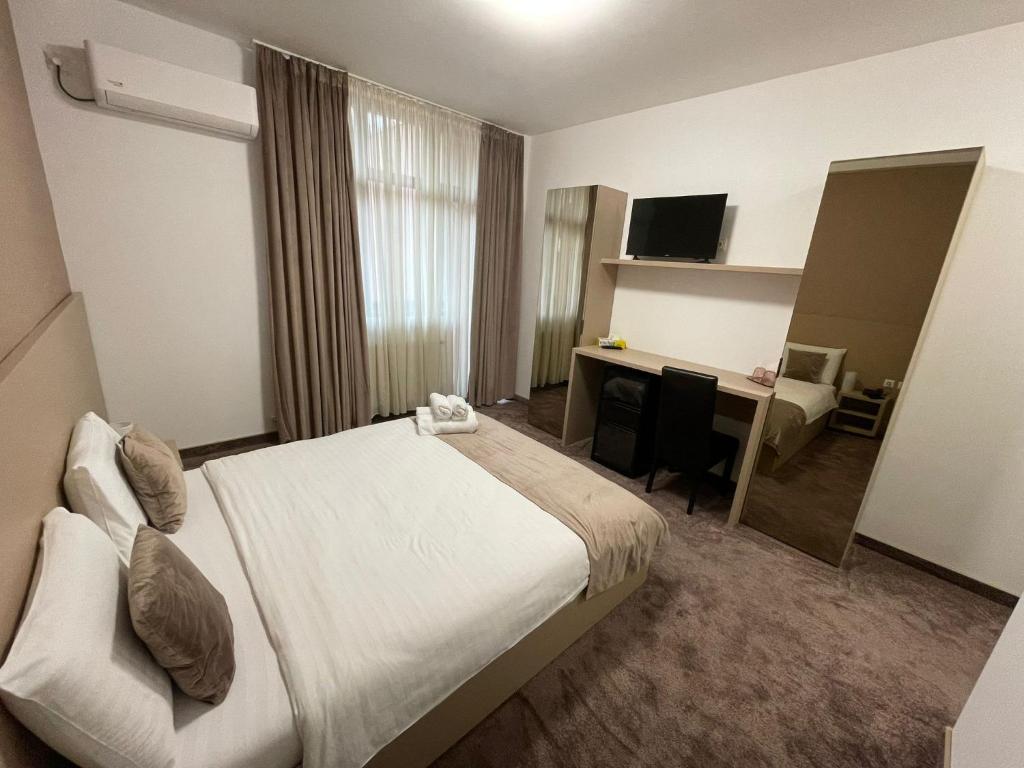 ブカレストにあるHotel Rivoliのベッドとデスクが備わるホテルルームです。