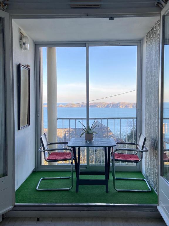 ペロス・ギレックにあるAppart n° 14, VUE MER, Perros-Guirecのテーブルと椅子、海の景色を望むバルコニー