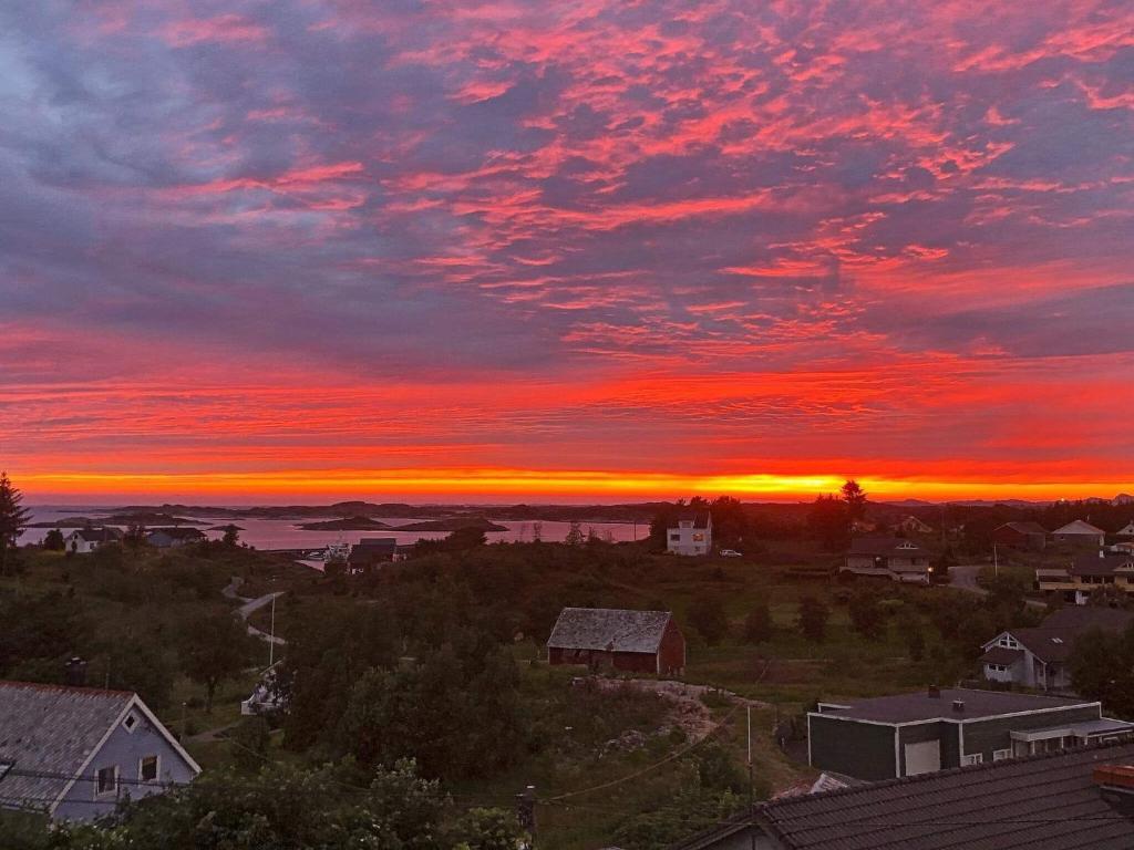 a sunset over a small town with a red sky at Holiday home byrknesøy in Ånneland
