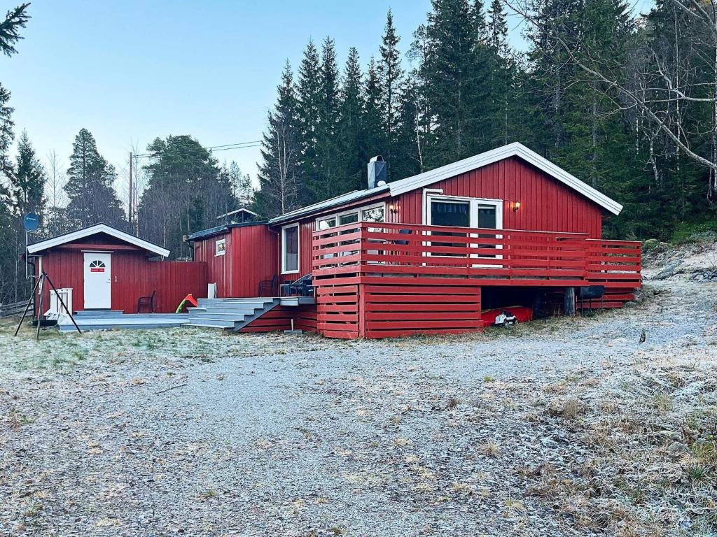 une cabine rouge avec une véranda et une maison dans l'établissement Holiday home Mosvik, à Mosvik