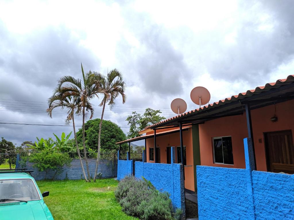 uma casa com uma cerca azul em frente em suítes Bomfass em Alto Paraíso de Goiás