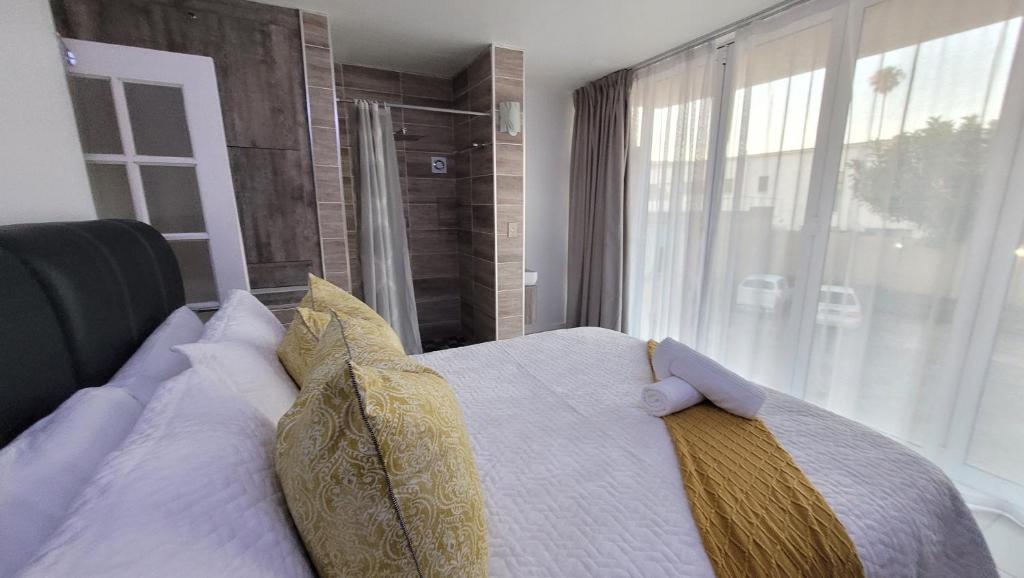 ein Schlafzimmer mit einem Bett mit Kissen und einem Fenster in der Unterkunft Effortless Self Catering Accommodation in East London