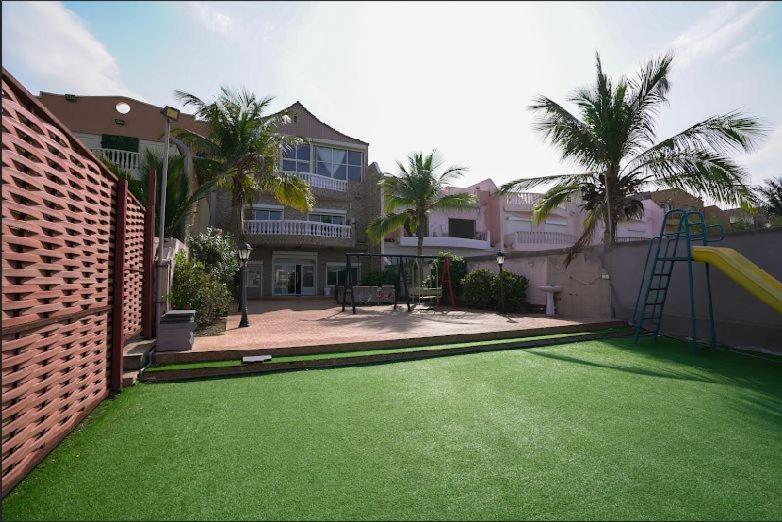 ein Haus mit einem Garten mit grünem Gras in der Unterkunft فيلا درة العروس in Durrat Al-Arus