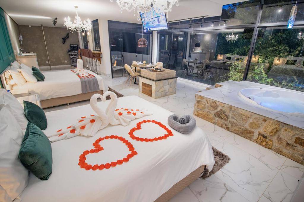 Habitación con bañera y cama con 2 cisnes en Resort Magnifico, en Monte Verde