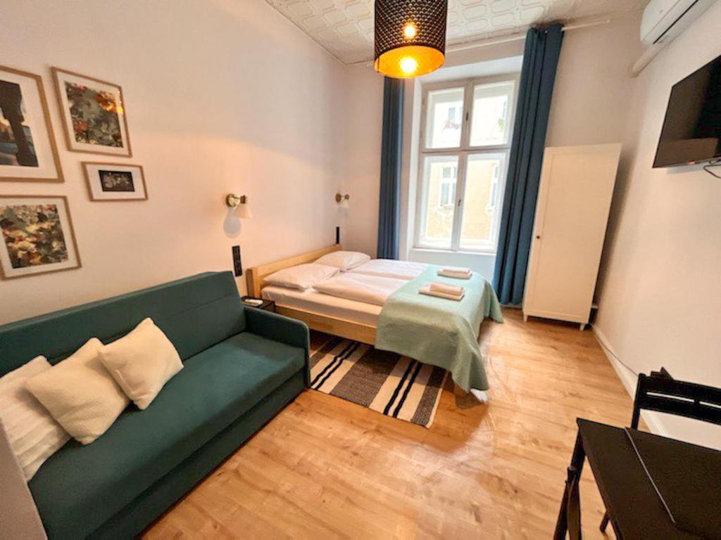a living room with a green couch and a bed at Supreme Apartment in the City Center in Kraków