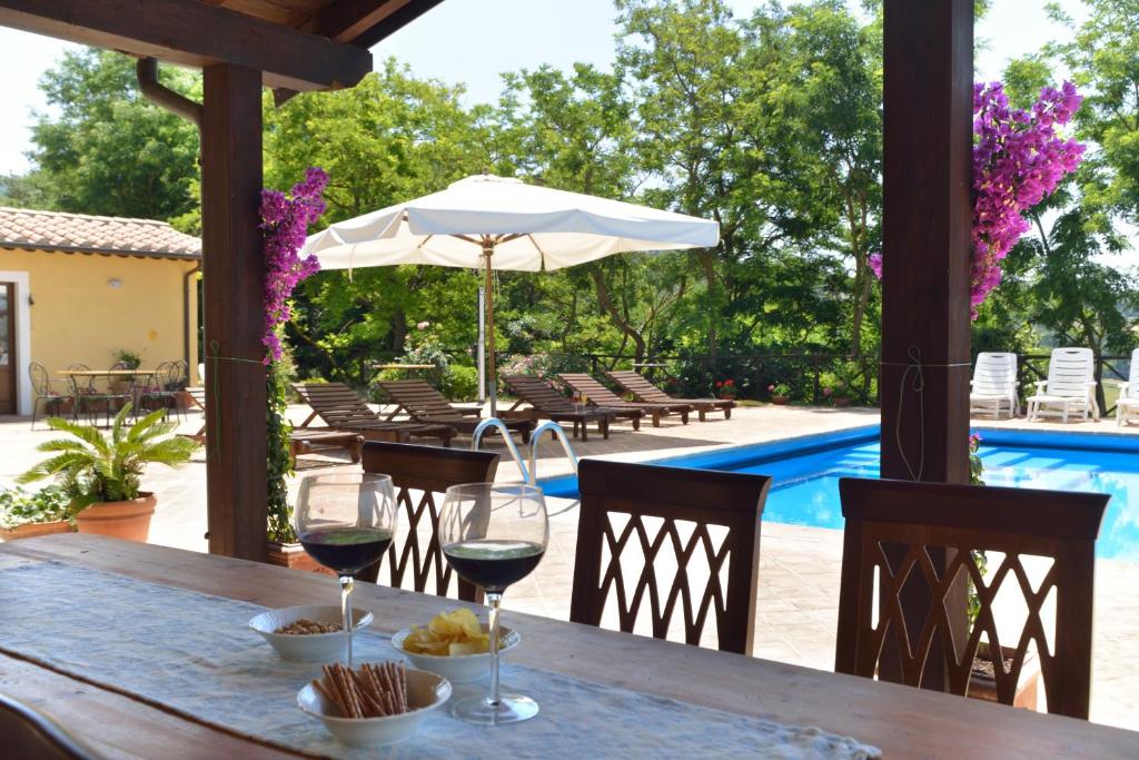 - une table avec deux verres de vin sur la terrasse dans l'établissement Villa Santa Maria Deruta, à Deruta