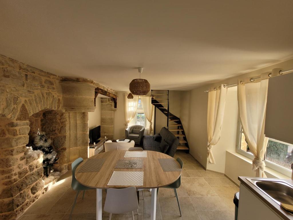 uma cozinha e sala de estar com uma mesa num quarto em Maisonette em Muret-le-Château