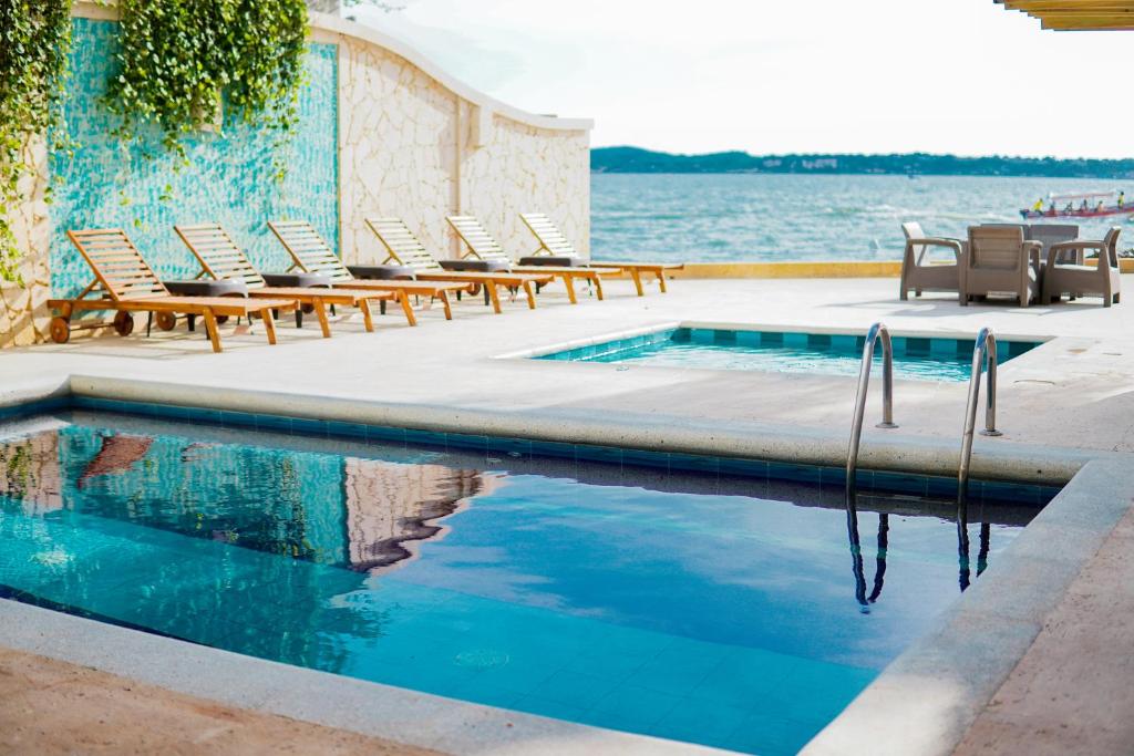 uma piscina com espreguiçadeiras junto à água em Hotel Caribbean Cartagena em Cartagena de Indias