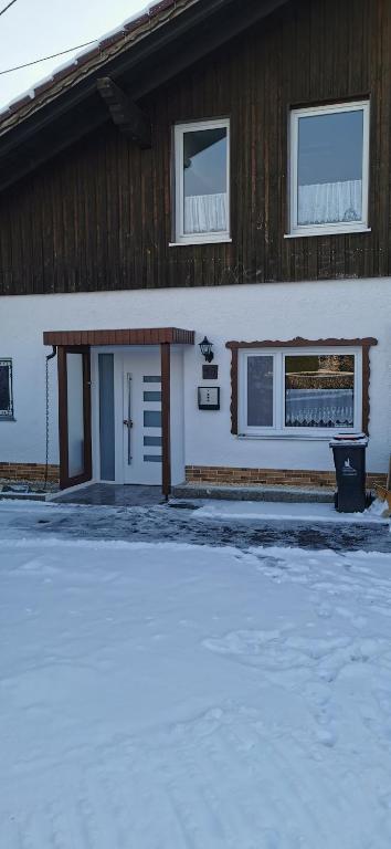 a house with a snow covered driveway in front of it at Linda in Ruderatshofen