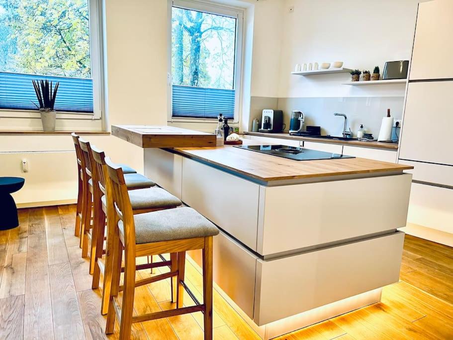 a kitchen with a counter and some chairs in it at Mi Casa 3 Zimmer geschmackvoll zentral in Bremen in Bremen