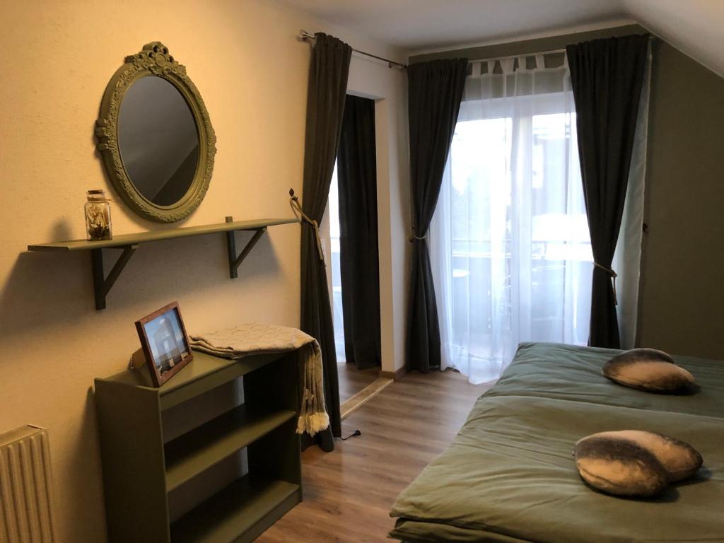 a bedroom with a bed and a mirror on the wall at Appartement Sonnenstrahl Ferienhaus Fuenf Sinne in Döbriach
