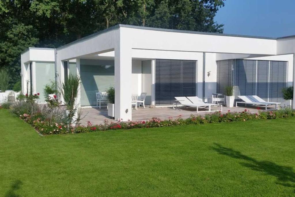 a white house with a lawn in front of it at Ferienhaus am Lünner See in Lünne