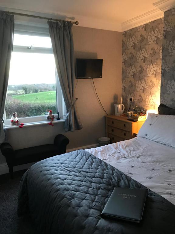 a bedroom with a bed and a window with a laptop on it at Dale View bed & breakfast in Holmrook