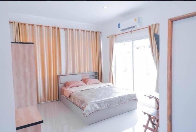 1 dormitorio con cama y ventana grande en Huen Raya - เฮือนรายา en Amphoe Mae Taeng