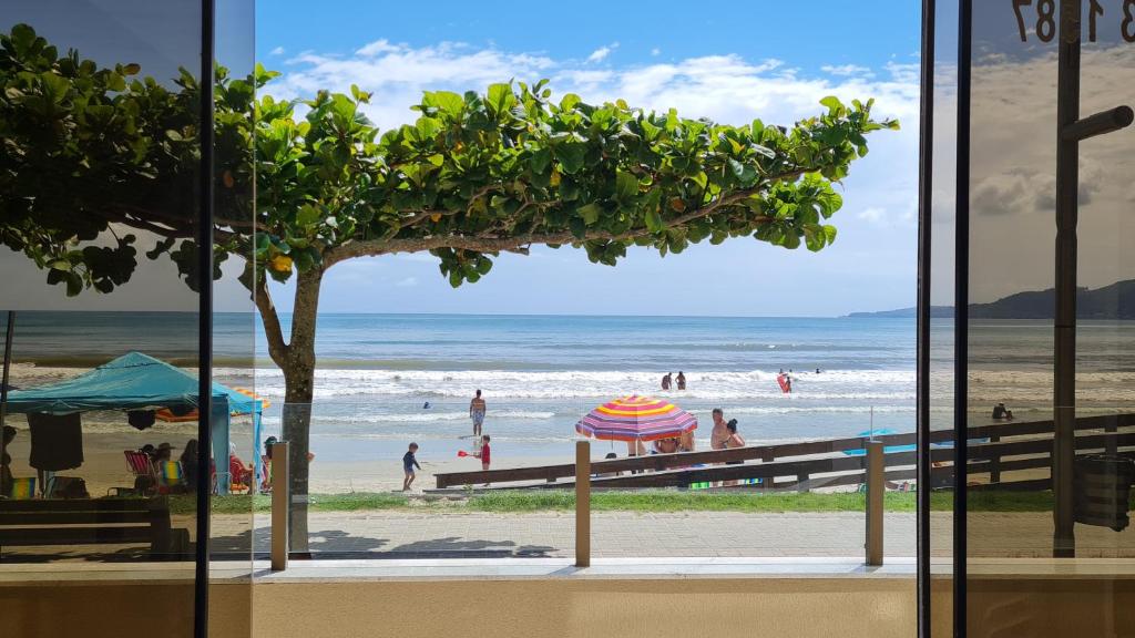 una ventana con vistas a la playa en Apto pé na areia em Meia Praia Itapema, 3 dormitórios, en Itapema