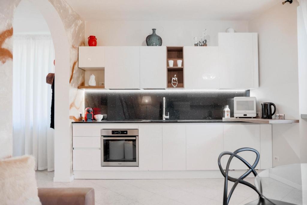 a kitchen with white cabinets and a stove at Fall In Love with Como Lake in Bellano