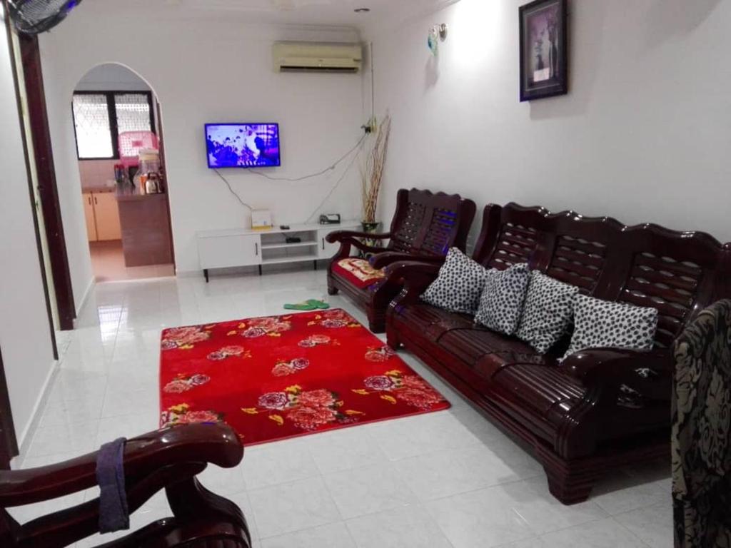 a living room with two leather couches and a red rug at Idaman guesthouse Malay only in Kubang Semang