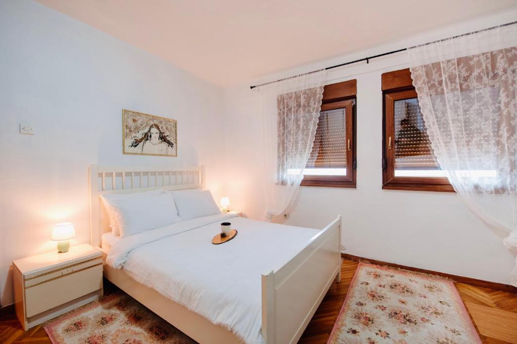 1 dormitorio con 1 cama blanca y 2 ventanas en CENTRAL Kolašin en Kolašin