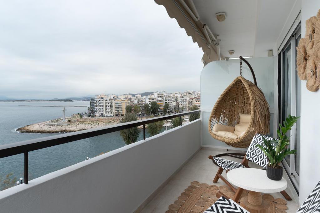 einen Balkon mit Hängematte und Blick auf das Wasser in der Unterkunft Blue Chill Paradise Seaview Suite w/ Kingbed in Piräus