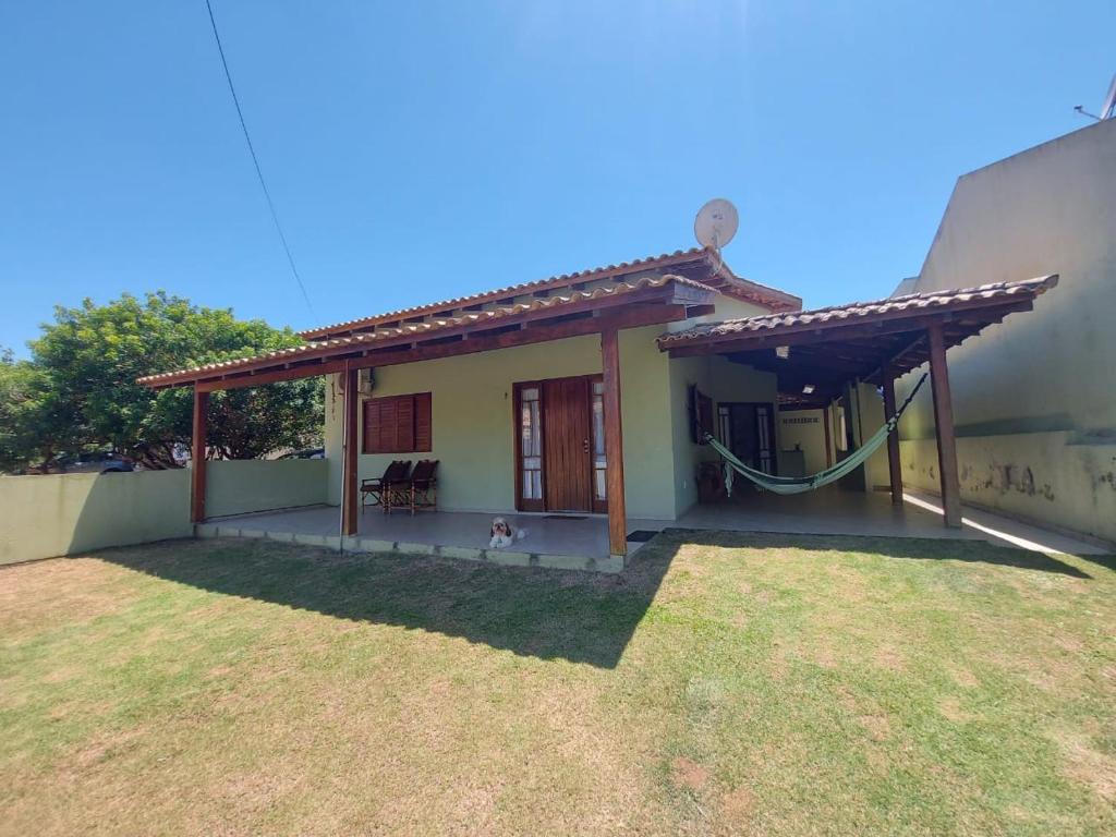 ein Haus mit einem Hund, der draußen sitzt. in der Unterkunft Casa Barra da Ibiraquera in Imbituba