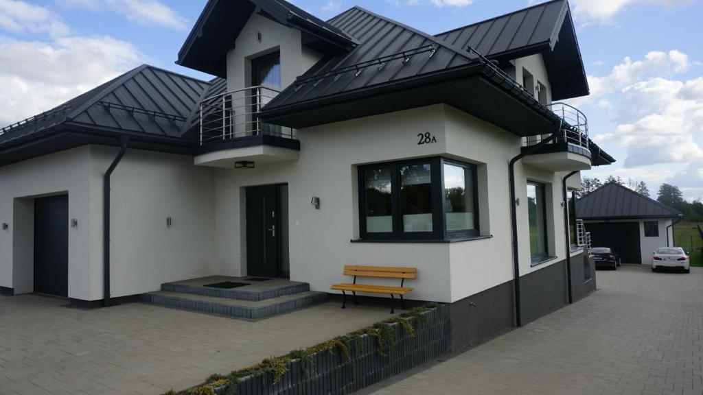 ein Haus mit einer Bank davor in der Unterkunft Agroturystyka Ostrowie in Dąbrowa Grodzieńska-Wieś