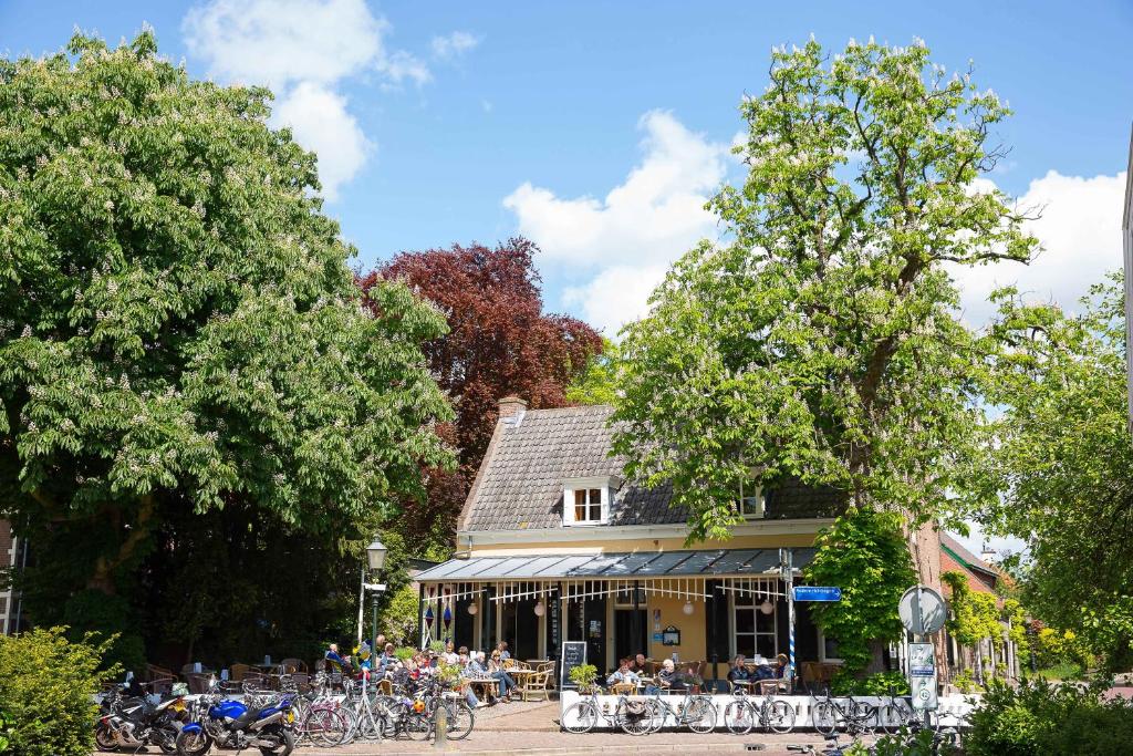 un groupe de personnes assises à des tables devant un bâtiment dans l'établissement Restaurant Hotel Buitenlust, à Amerongen