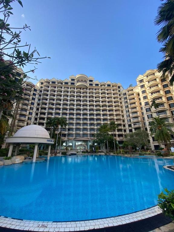 a large building with a large blue swimming pool at Riviera Bay Resort Condominium in Kampong Lereh